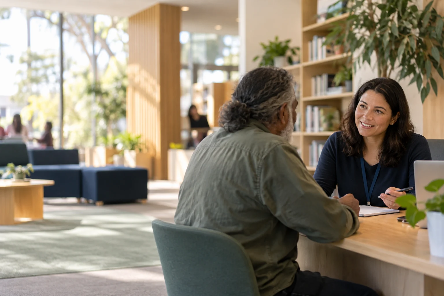 A community member speaking with a legal adviser at a welcoming service desk